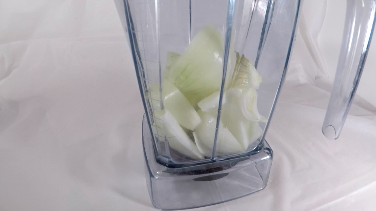 blender container filled with large pieces of onion